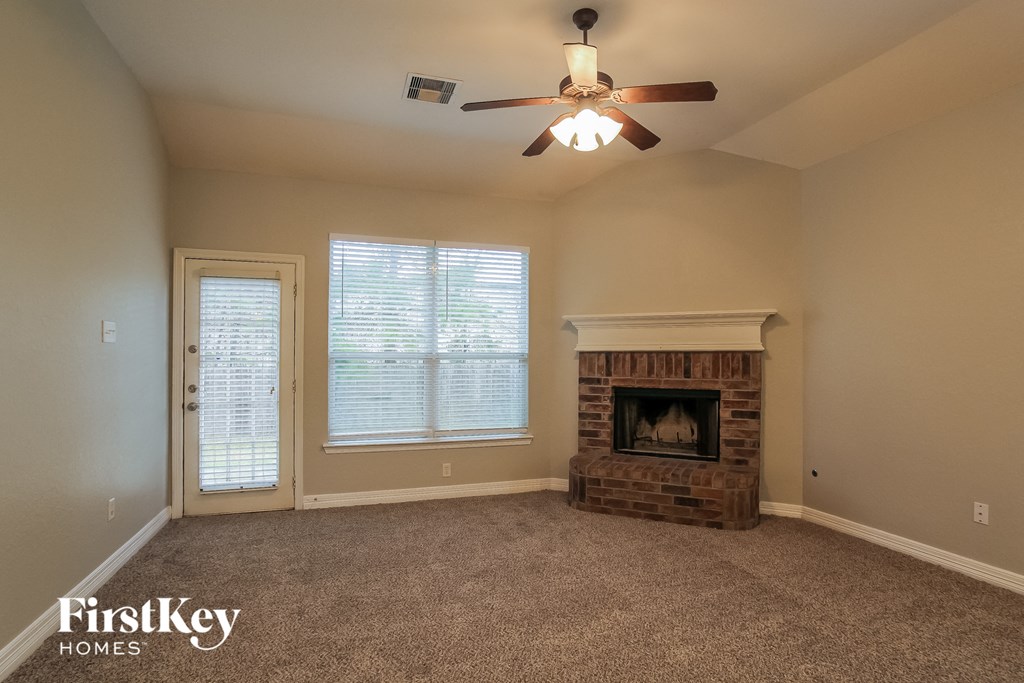 a living room with a fireplace and a ceiling fan