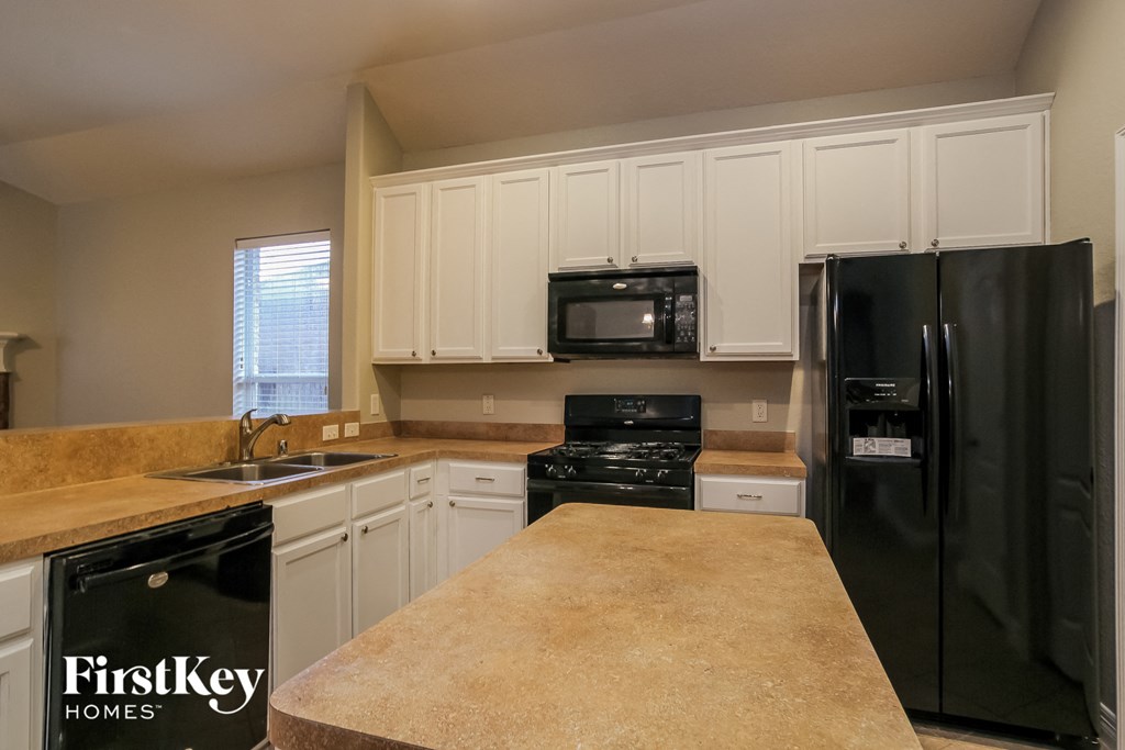 a kitchen with black appliances and white cabinets