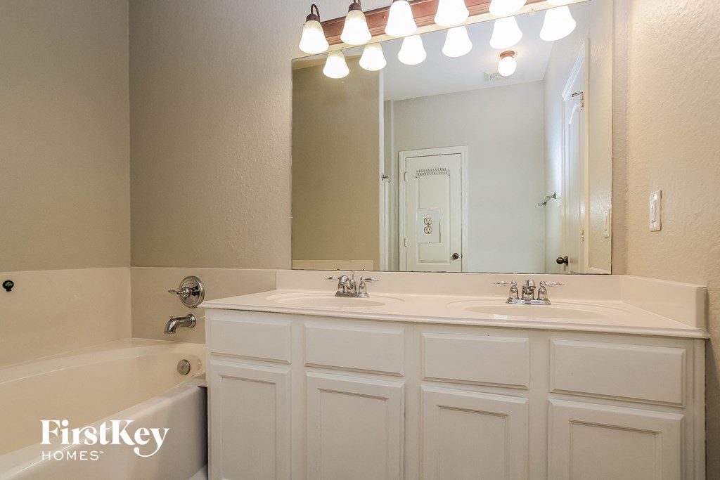 a bathroom with a sink and a mirror and a bath tub