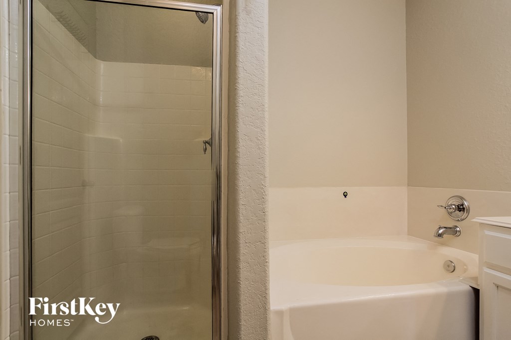 a bathroom with a shower and a tub and a sink