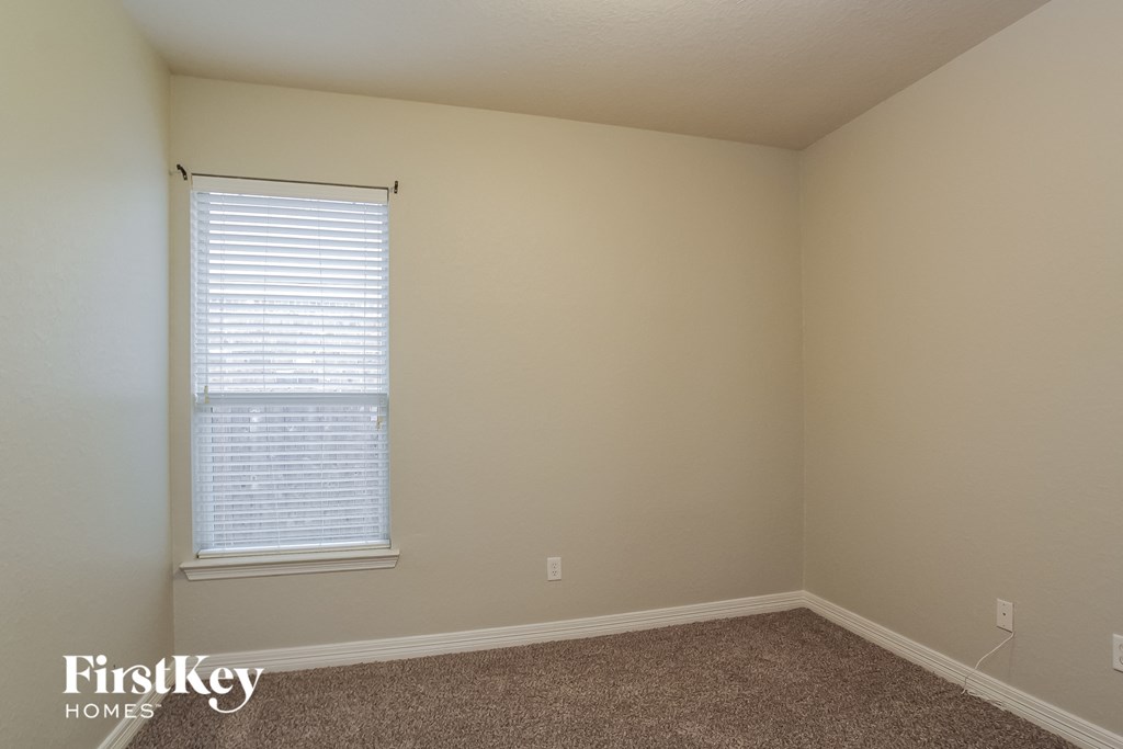 a room with beige walls and a window and a carpet