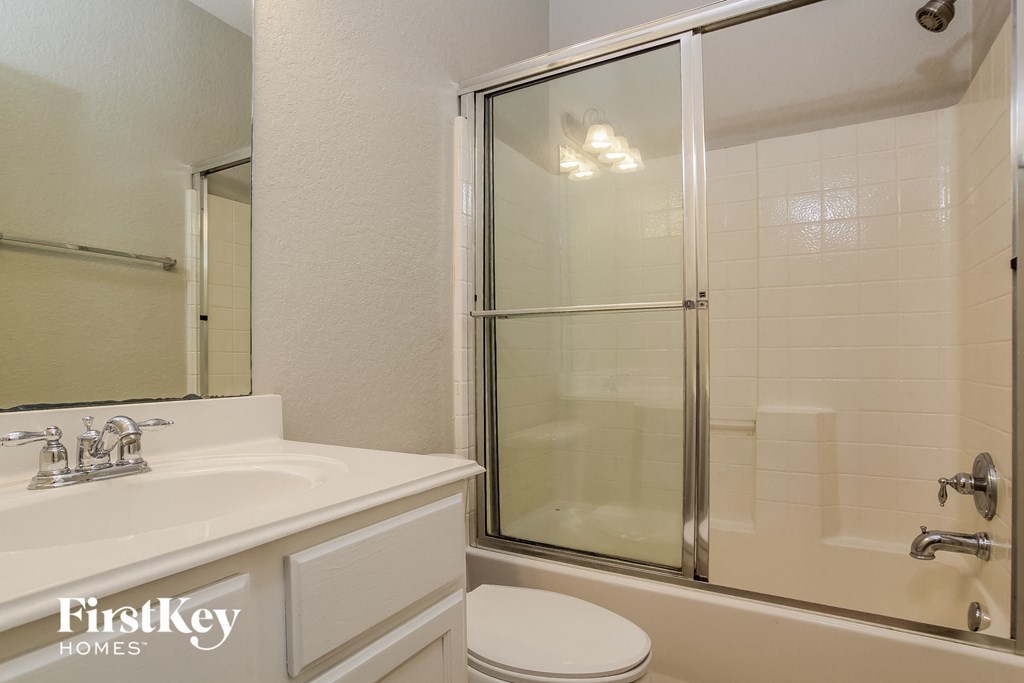 a bathroom with a shower and a sink and a toilet