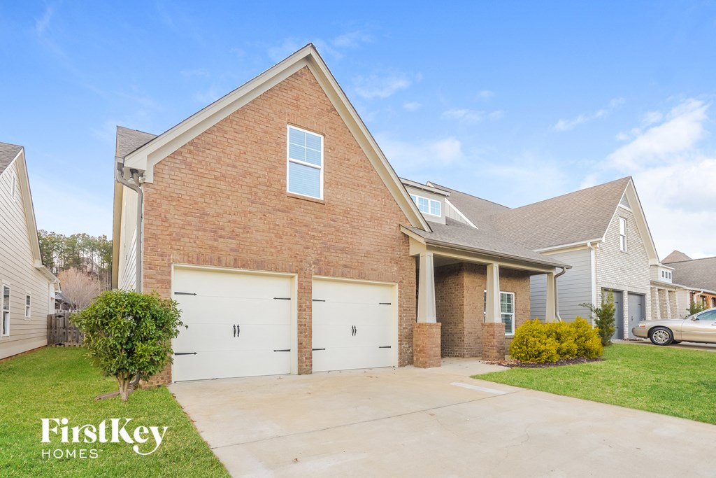 a brick house with two garage doors and a driveway