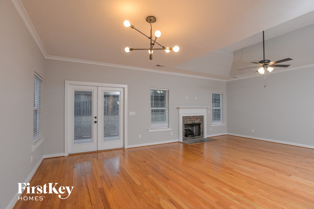 the living room with wood floors and a fireplace