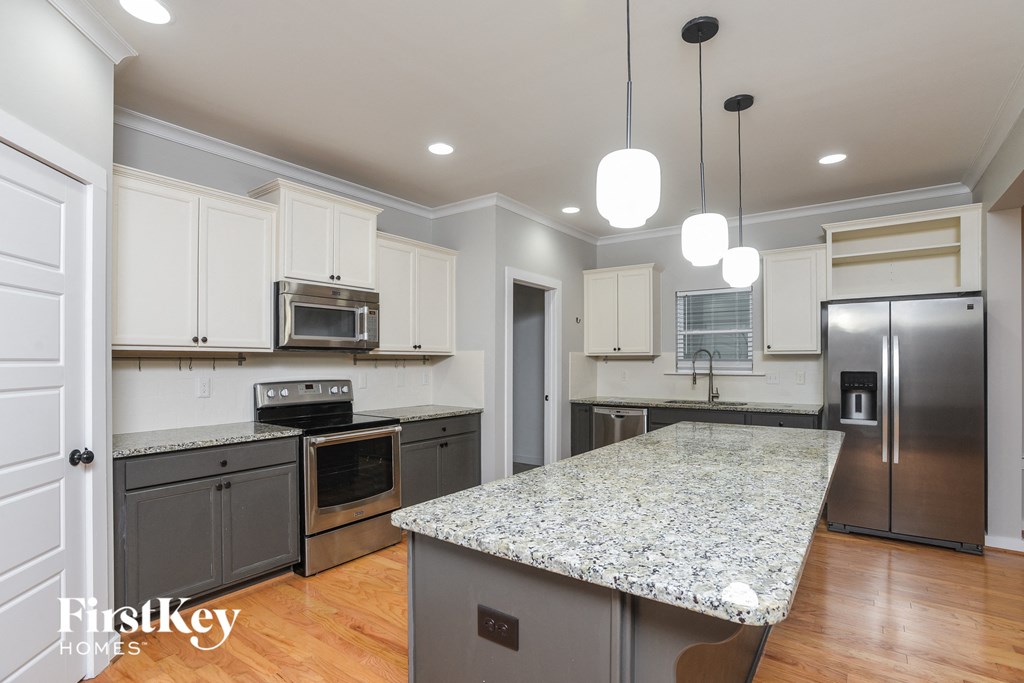 a renovated kitchen with granite countertops and stainless steel appliances