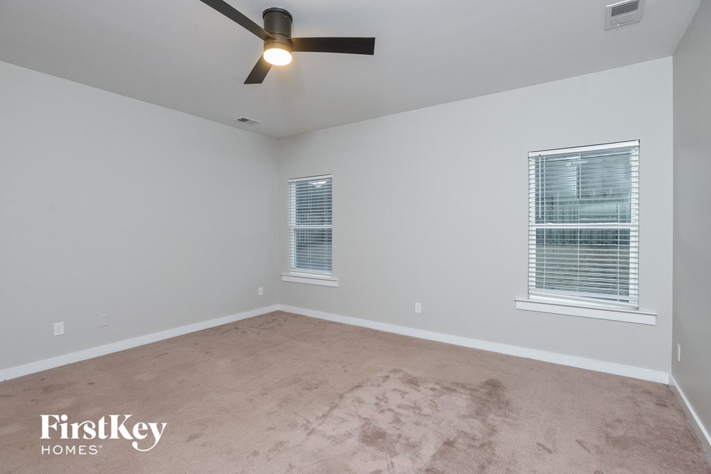 the bedroom with carpet and ceiling fan in an empty room
