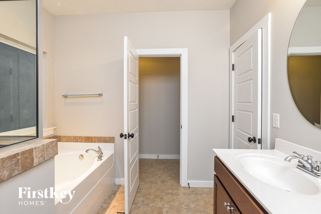 a bathroom with a tub and a sink and a mirror
