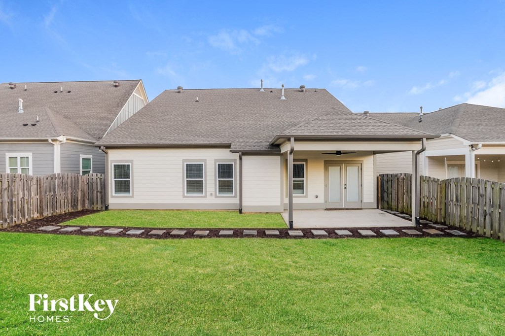 a white house with a yard and a wooden fence