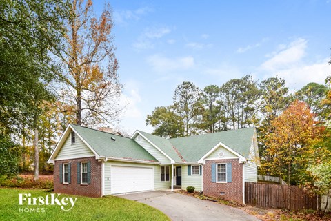 a white and brick house with a green roof
