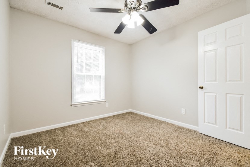 a bedroom with a ceiling fan and a white door