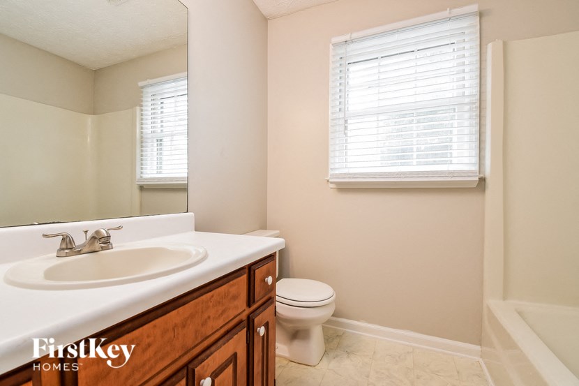 a bathroom with a toilet and a sink and a mirror