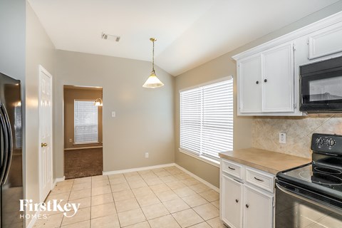 A kitchen with a stove top oven and a refrigerator.
