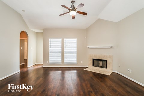 a living room with a fireplace and a ceiling fan