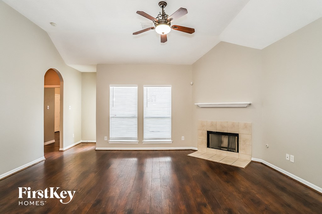a living room with a fireplace and a ceiling fan