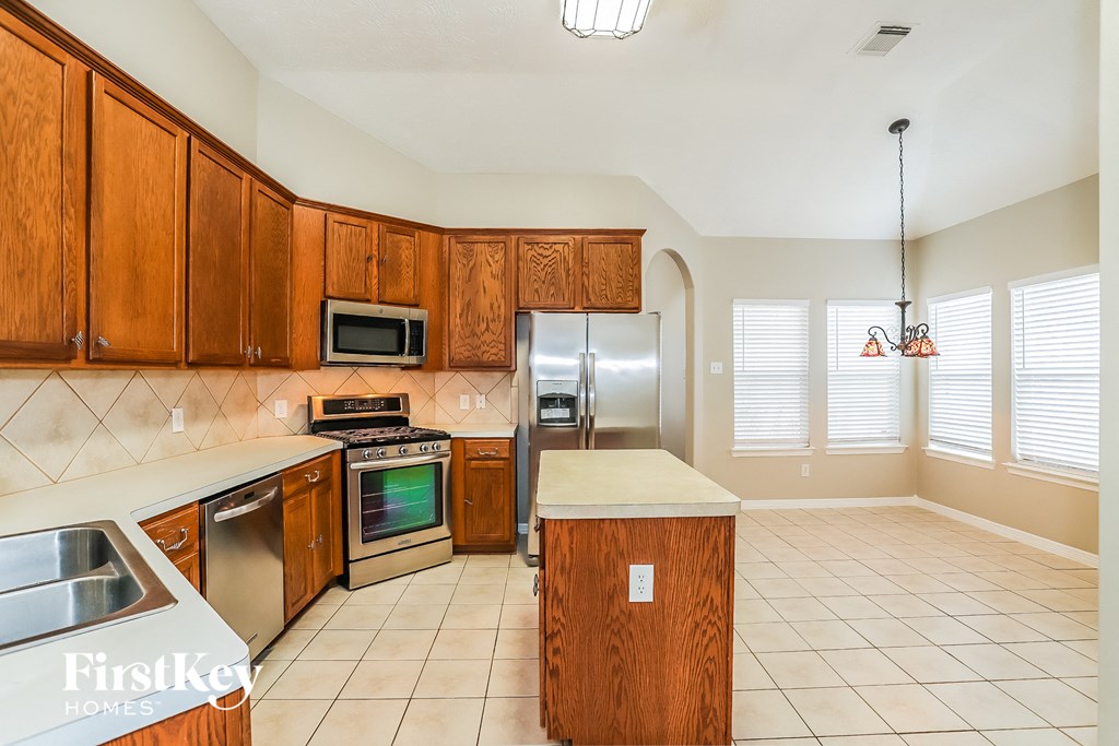 a kitchen with wooden cabinets and stainless steel appliances