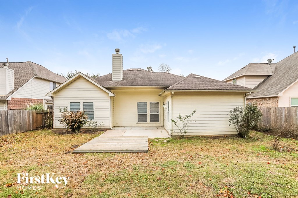 a small white house with a yard and a wooden walkway