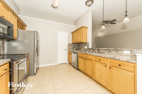 A kitchen with wooden cabinets and a marble countertop.