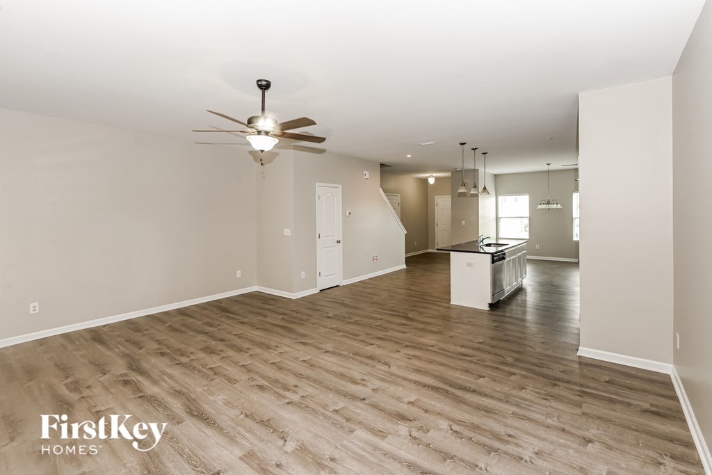 A spacious room with a ceiling fan and wooden flooring.