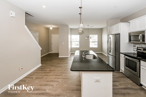 A kitchen with a black counter top and white cabinets.