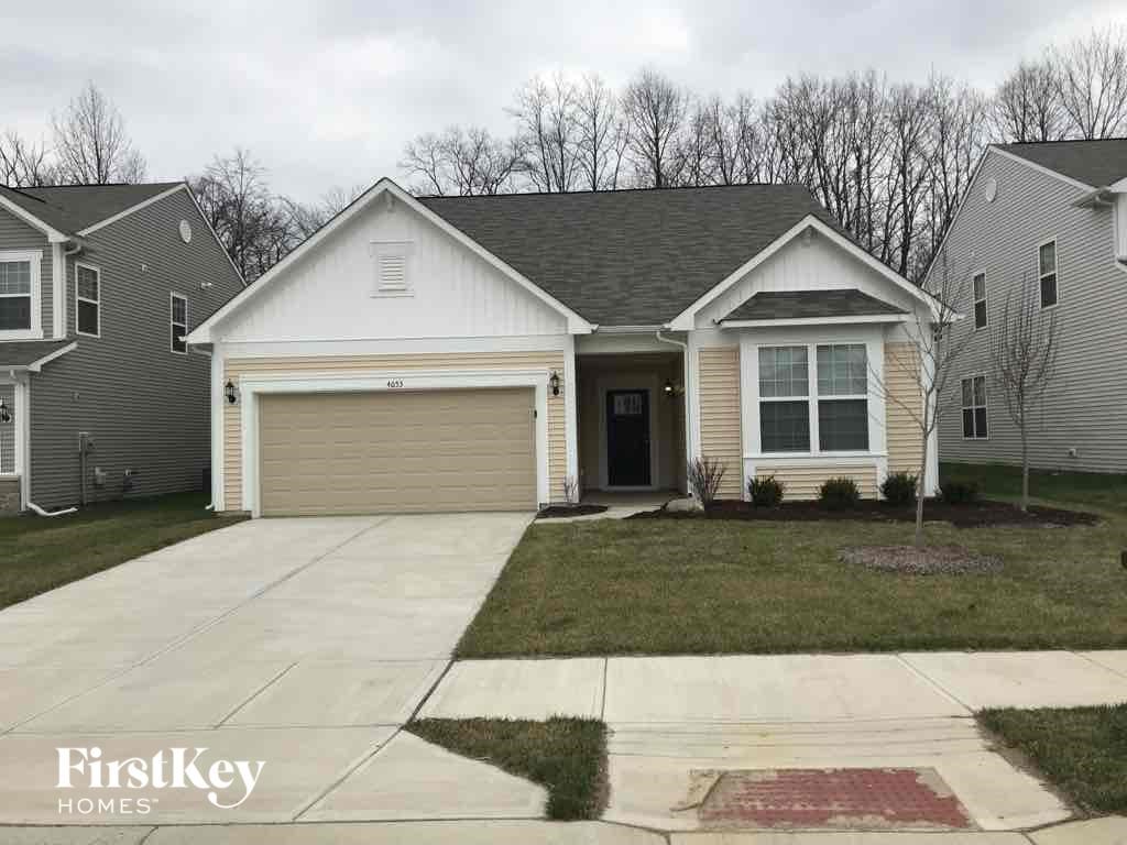 A house with a garage and a driveway in front of it.