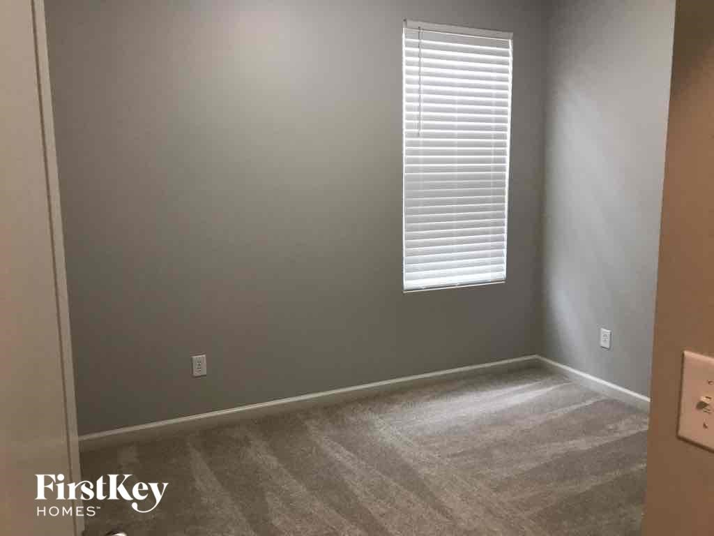 A room with a window and a carpeted floor.