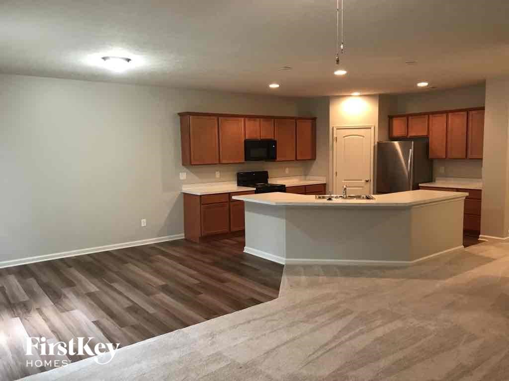A kitchen with wooden cabinets and a white island.