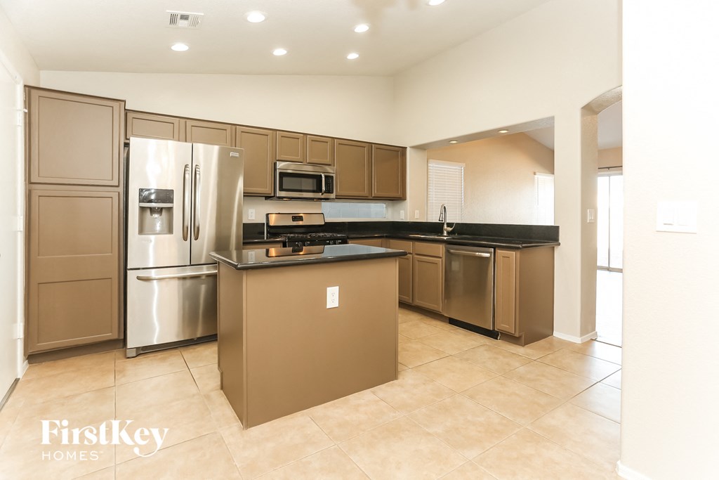 A kitchen with a refrigerator, microwave, oven, and dishwasher.