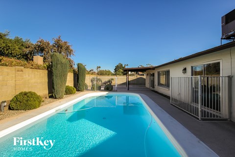 A swimming pool in a backyard with a FirstKey Homes logo.