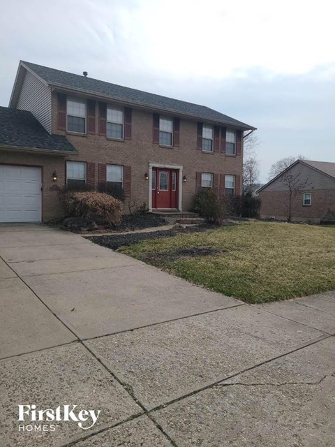 a brick house with a red door and a sidewalk