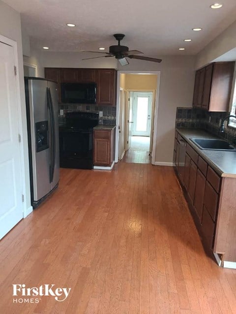 a kitchen with a wood floor and a stainless steel refrigerator