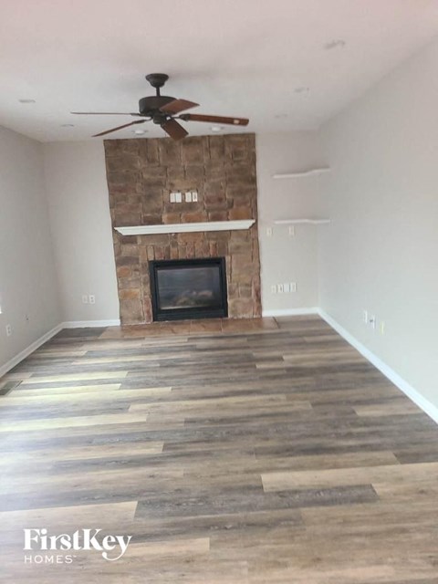 a living room with a fireplace and a ceiling fan