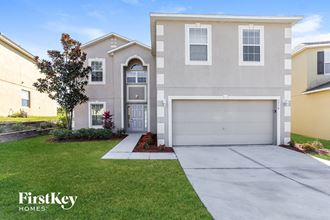a beige house with a garage door and a lawn