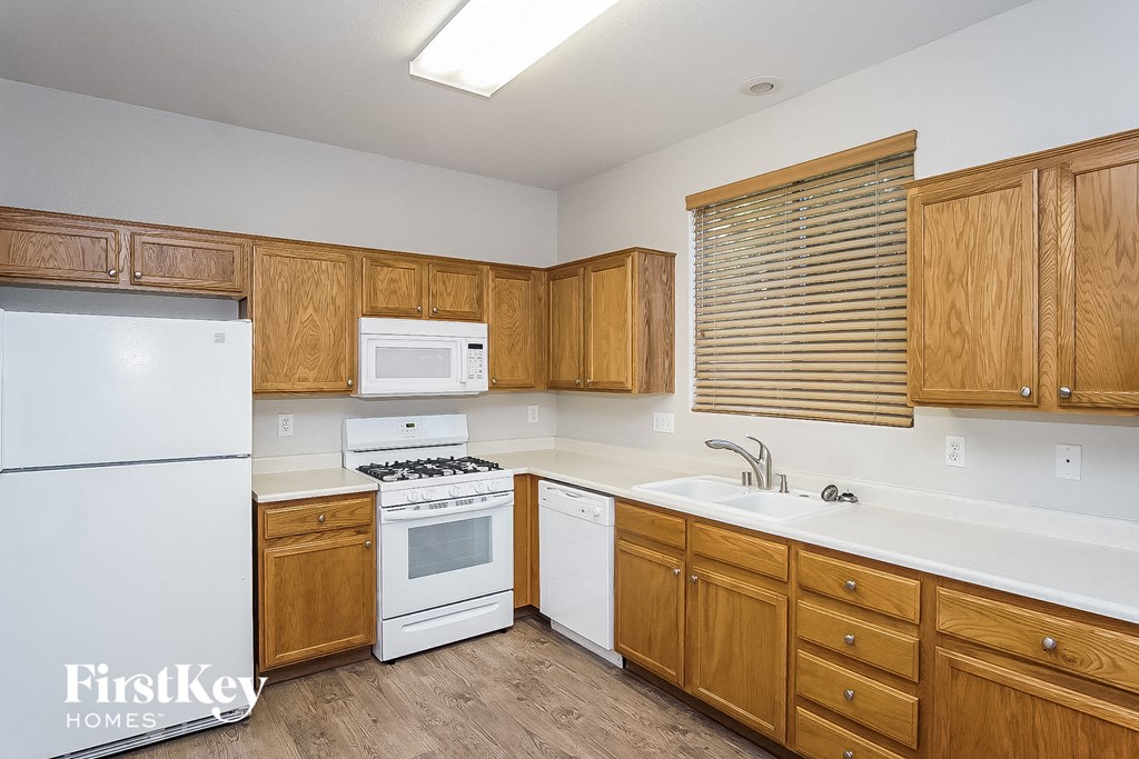 A kitchen with wooden cabinets and white appliances.