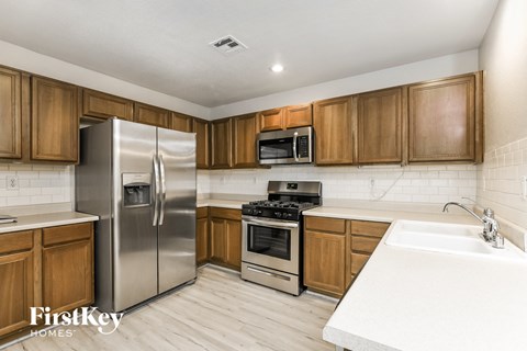 A kitchen with wooden cabinets and a stainless steel refrigerator.