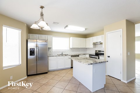 a kitchen with white cabinets and a stainless steel refrigerator