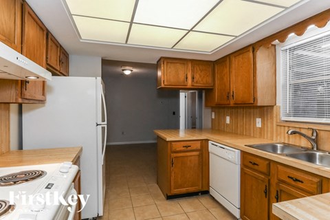 A kitchen with wooden cabinets and a white refrigerator.
