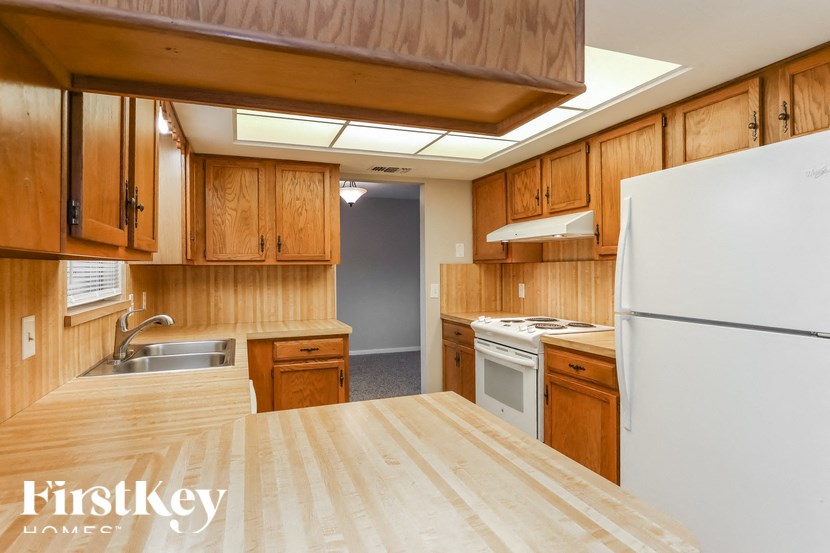 A kitchen with wooden cabinets and a white refrigerator.