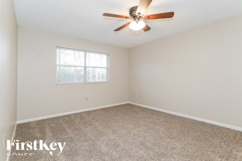 A room with a ceiling fan and a window.