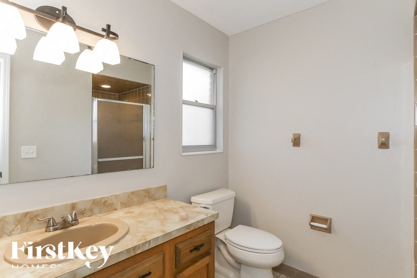 A bathroom with a marble countertop and a large mirror.