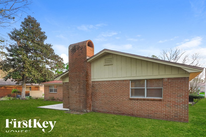 A house with a chimney and a tree in front of it.