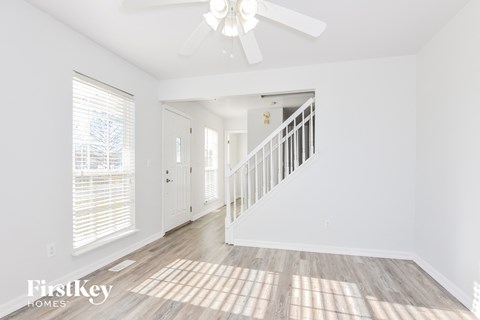 A spacious room with a staircase leading to the second floor.
