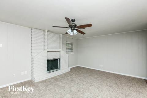 A room with a fireplace and a ceiling fan.