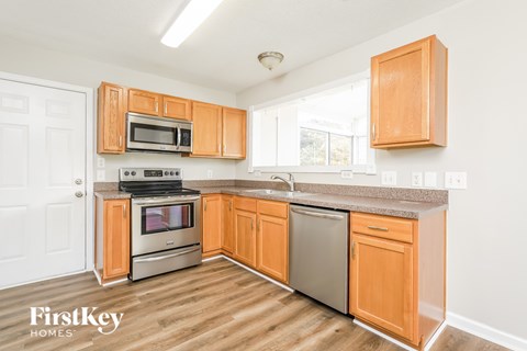 A kitchen with wooden cabinets and a stainless steel dishwasher.