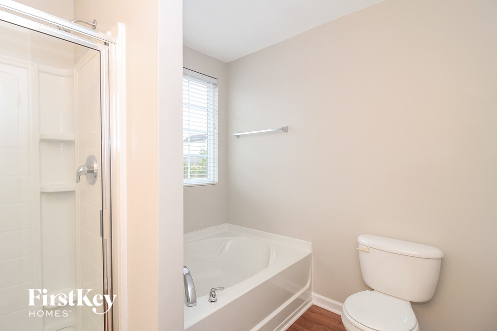 a bathroom with a toilet and a tub and a shower