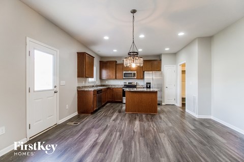 A well-lit kitchen with wooden floors and a central island.