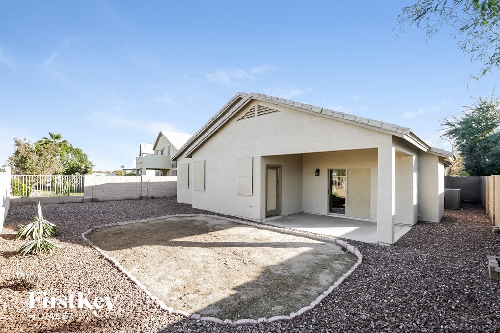 A modern house with a white exterior and a gravel driveway.