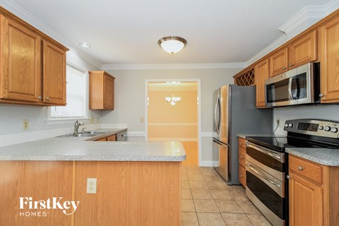 A kitchen with wooden cabinets and a refrigerator.