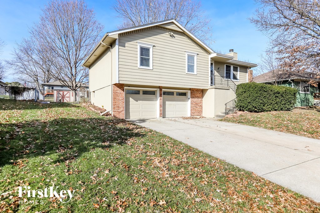a home with two garage doors and a sidewalk