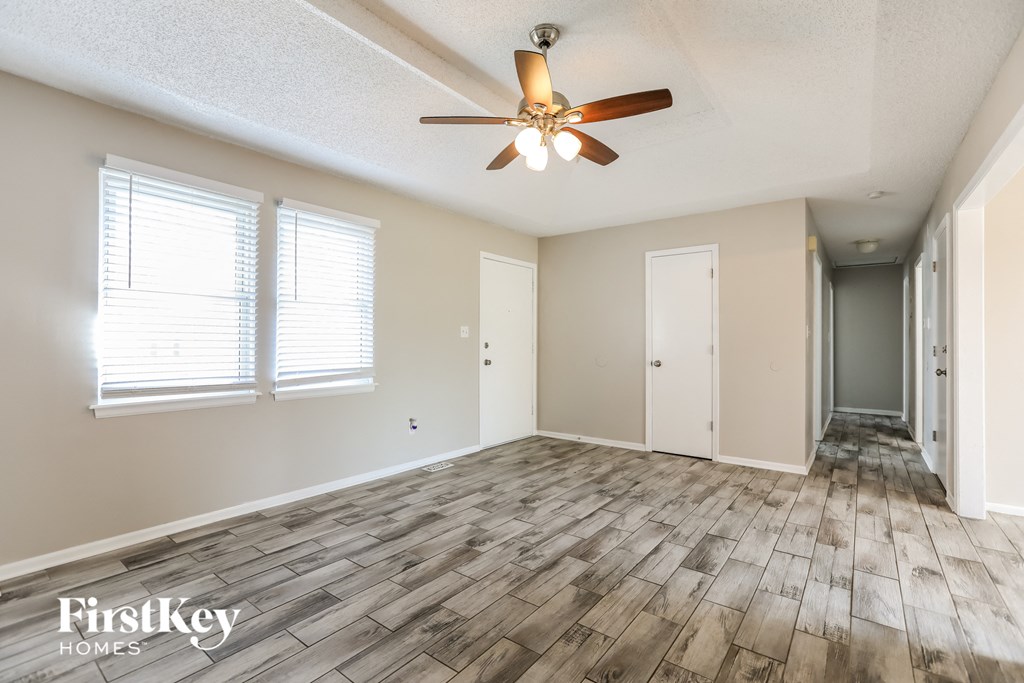 the living room with wood floors and a ceiling fan