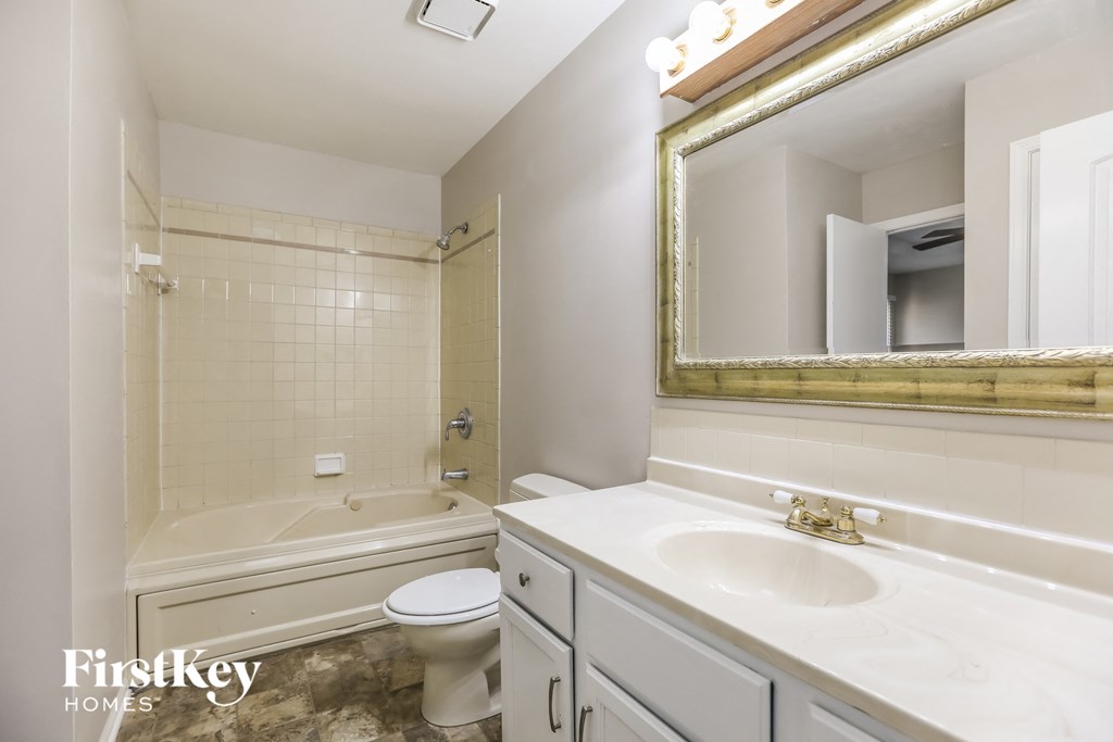 a bathroom with a sink toilet and tub and a mirror